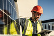 © Westend61 - Smiling engineer wearing protective workwear using digital tablet by solar panel