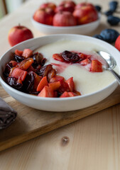 Wall Mural - Semolina porridge with fresh cooked plums and apples on a plate. Lactose free