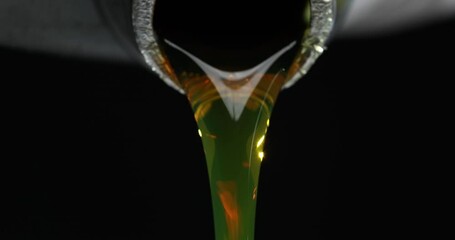 Wall Mural - Yellow motor oil pouring from bottle macro closeup 4k movie slow motion. Engine oil change concept 