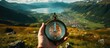Compass in hand on the background of the mountains and the lake.