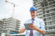 © Minerva Studio - Site manager using his tablet in front of a construction site