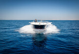 Front view of a sports motor boat cruising with high speed over the blue ocean
