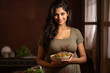 © PRASANNAPIX - pregnant woman standing at kitchen and cooking healthy food for herself.
