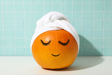 Wall Mural - Skin and face care concept - pumpkin with eyelashes and towel