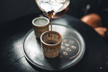 Wall Mural - Black coffee is being poured into a ceramic mug.