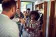 © Marko Geber - Young and diverse group of friends receiving the keys and meeting the owner of their rented lake house