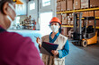 © Marko Geber - Young woman going over inventory with a coworker in a warehouse