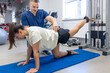 © puhimec - Woman does legs raise exercise, therapist helping with mechanical disorders.