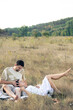 © puhimec - Happy married man and woman on a date relaxing in the field.