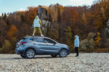 Poster - woman on the car man near stopped at mountain river beach autumn season