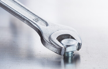 Wall Mural - Wrench tightens bolt in steel billet. Spanner, bolt, screw and nuts.