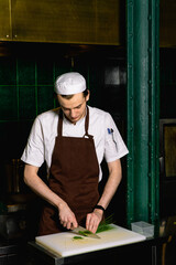 chef preparing food in the kitchen at the restaurant cutting cook hands hotel man male knife preparation fresh preparing concept 