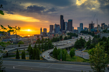 Wall Mural - Dramatic sunset over the Seattle downtown skyline, with traffic on the I-5 and I-90 freeway interchange, viewed from Dr. Jose Rizal Bridge.