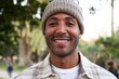 Portrait of multiethnic young man smiling and looking at camera. Friendly happy African American male person outdoors. Close up.