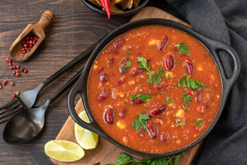 Wall Mural - Bean and corn soup or ragout, red bean stew on a wooden background. Food Protein Vegan dish