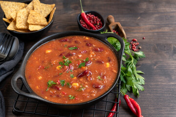 Wall Mural - Bean and corn soup or ragout, red bean stew on a wooden background. Food Protein Vegan dish