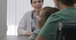 © Framestock - Female pediatrician consults patient with cute little child on appointment in hospital. Woman sits on chair at physician checkup. Friendly doctor works in modern medical center. Close up. Back view.