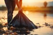 At sunset, a hand holds a black garbage bag, river cleanup underway
