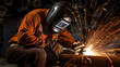 © Alin - Welder welding metal, lots of sparks, wearing protective welding gear