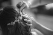 Hairdresser making an elegant hairstyle for a bride, black and white, back view