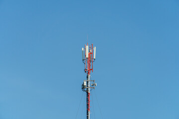 New GSM antennas on a high tower against a blue sky for transmitting a 5g signal are dangerous to health. Radiation pollution of the environment through cell towers. The threat of extinction