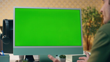 Wall Mural - Designer video chatting mockup monitor in workplace. Man having internet call