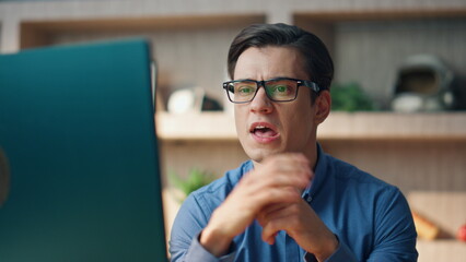 Wall Mural - nervous startuper disputing monitor online call at work closeup. man quarrelling