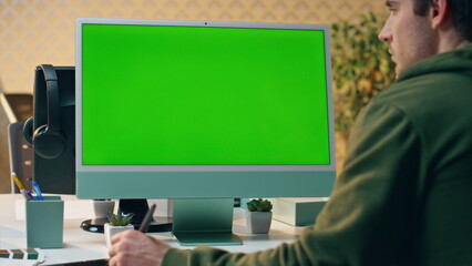 Wall Mural - Focused artist staring green screen creating tablet close up. Designer working