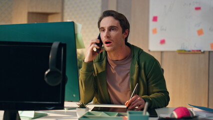 Wall Mural - Web designer consulting smartphone at workplace close up. Man drawing tablet