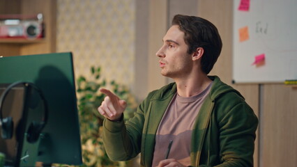 Wall Mural - Talking freelancer watching monitor at workplace close up. Guy staring computer