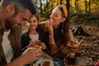 © bernardbodo - Mother, father and their daughter eating fruit during forest picnic