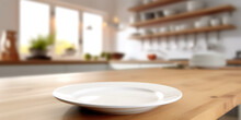 Kitchen With Empty Table And White Plate. Blurred Background. Space For Brand, Advertising, Or Product