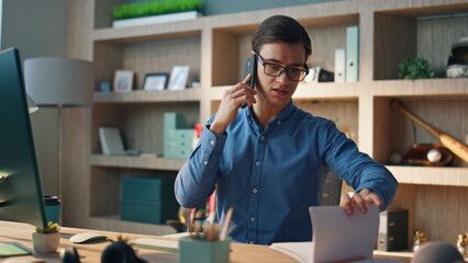 Wall Mural - Focused freelancer chatting mobile phone at office closeup. Creator having call