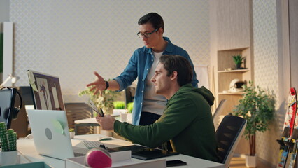 Wall Mural - Smiling colleagues working computer in office. Eyeglasses man giving advices
