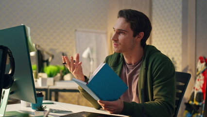 Wall Mural - positive man having virtual call modern office. freelancer reading notes talking