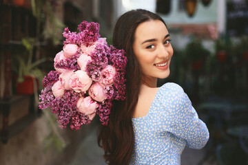 Poster - Beautiful woman with bouquet of spring flowers outdoors