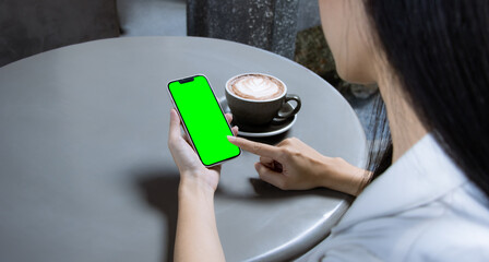 Poster - Woman holding and touching on blank screen smartphone at the coffee cafe. Technology and lifestyle.
