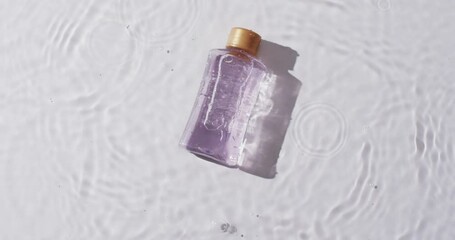 Canvas Print - Video of beauty product bottle in water with copy space on white background