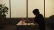 Silhouette of adult male sitting at the bistro bar, man having dinner alone, eating pizza and drinking juice.