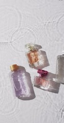 Canvas Print - Vertical video of beauty product bottles in water with copy space on white background