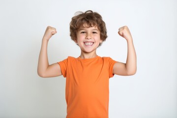 Portrait of a smiling little boy showing his muscles on white background