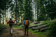 © La Famiglia - A multiethnic couple sets off on an invigorating hike, equipped with backpacks and walking poles to conquer the challenging yet rewarding trail