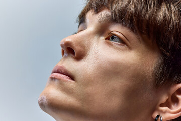 fresh, male face. cropped closeup portrait of young attractive brunette man looking away against ove