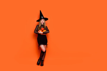 Canvas Print - Full body photo of attractive blonde teen woman hold pumpkins dressed black halloween clothes isolated on orange color background