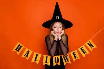 Canvas Print - Photo of funny excited girl dressed dark witch dress headwear looking halloween decorations isolated orange color background