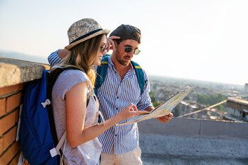 Wall Mural - happy couple on vacation sightseeing city with map. people travel fun love concept.