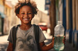 a young boy is standing and smiling holding a bottle of water, concept of lacking of clean water worldwide