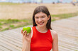 © luismolinero - Young pretty woman at outdoors with an apple and happy