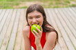 © luismolinero - Young pretty woman at outdoors holding an apple