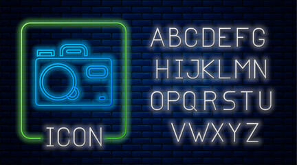 Poster - Glowing neon Photo camera icon isolated on brick wall background. Foto camera. Digital photography. Neon light alphabet. Vector